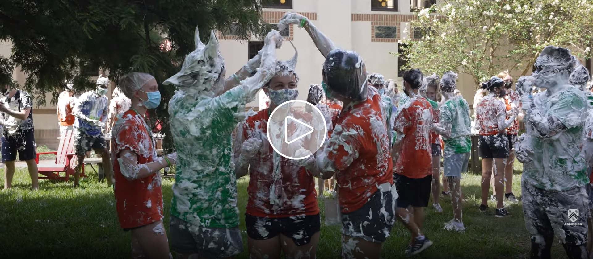 New students are covered in shaving cream outside Baker College for an O-Week event