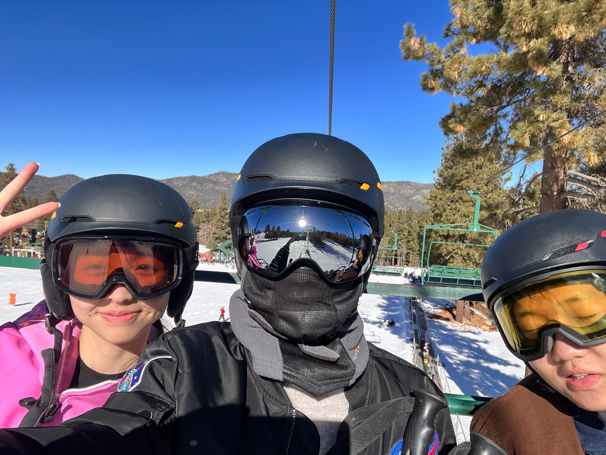 Three students wearing ski gear on a goondola.