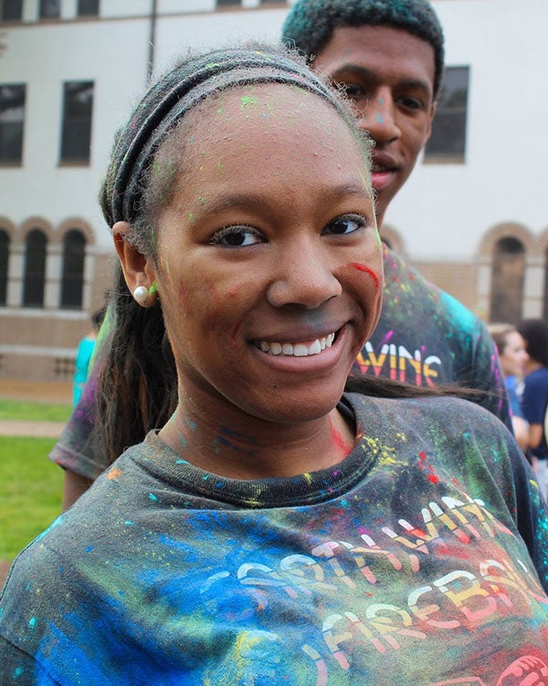 Valencia smiles for a picture while covered in colorful dust from Holi.