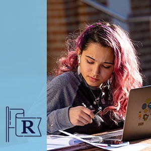 A female student studying by a laptop