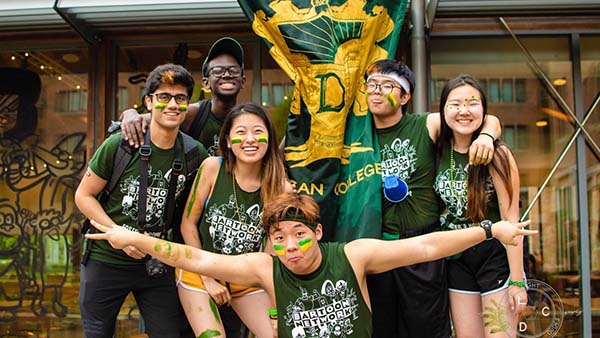 Sarah poses with her fellow Duncaroos in front of the Dunc Tank. Everyone is dressed up in green and gold, Duncan's colors, for Willy Week. 