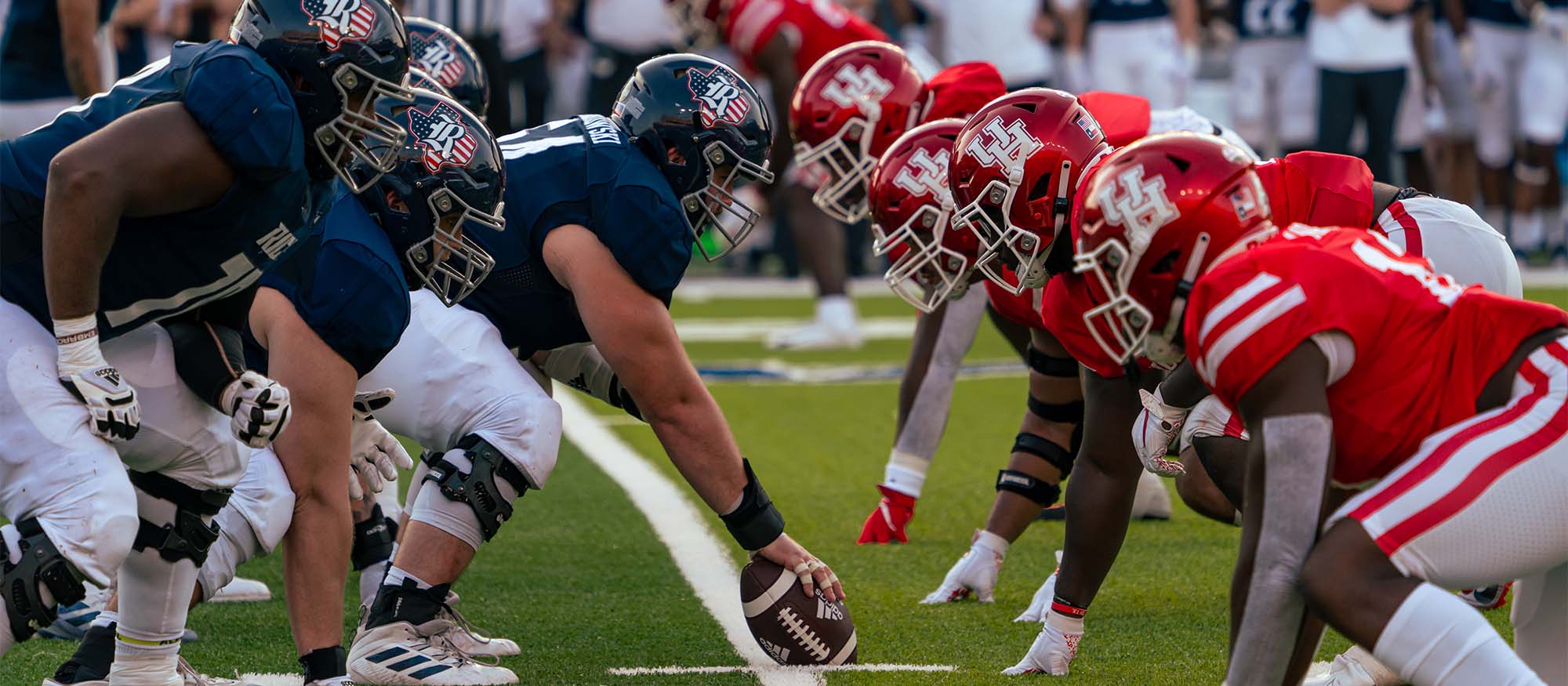 The Rice offensive line on the left faces the University of Houston defensive line on the right, as Rice is about to snap the ball.