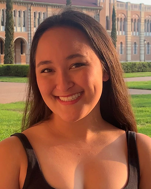 Isabel smiles for a headshot on Rice's campus in front of the academic quad.