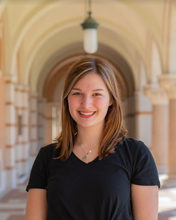 Grace smiles for a headshot in the cloisters of Lovett Hall.