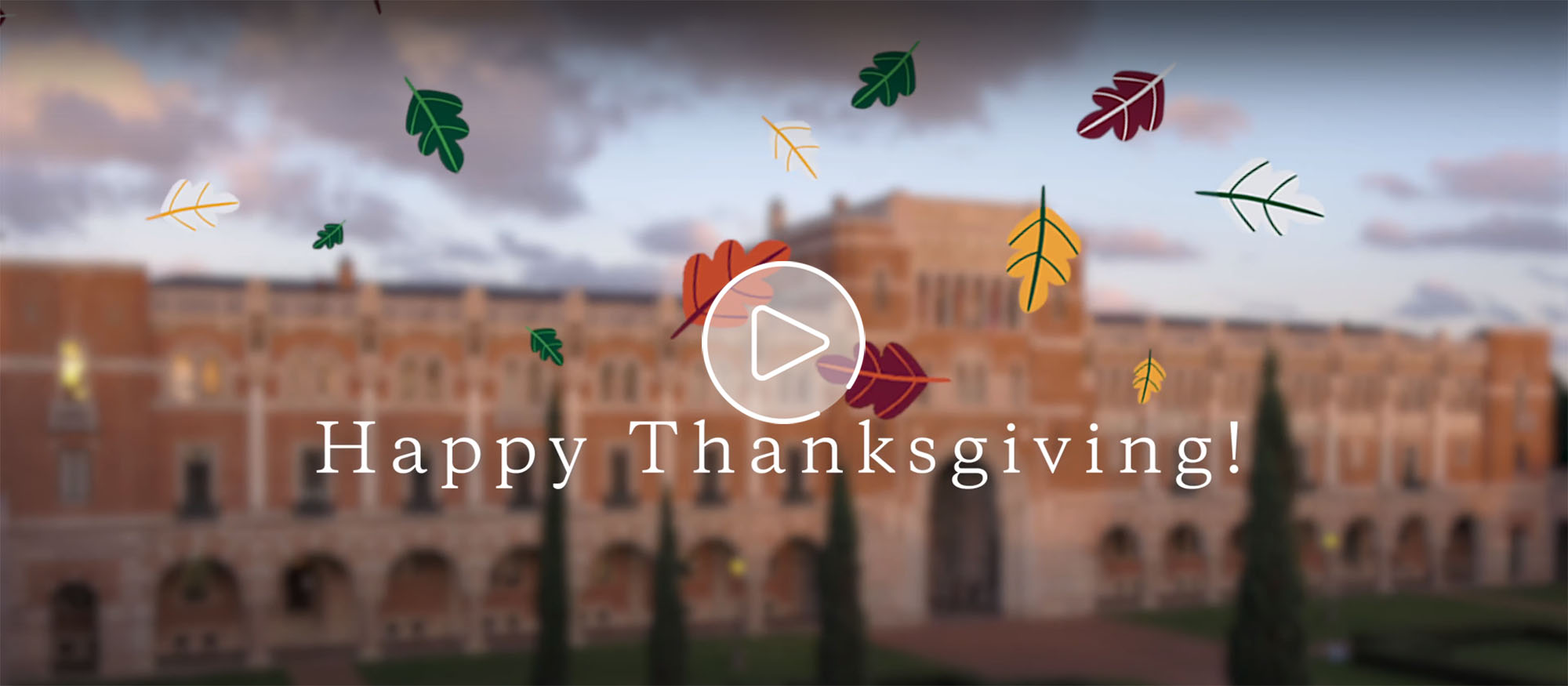A still from the video featuring the front of Lovett Hall and overlay text reading "Happy Thanksgiving" as well as a graphic of red and green leaves falling down.