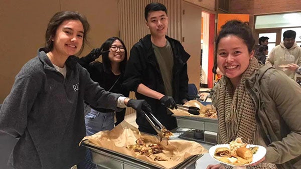 A group of students serving the breakfast items at the Pancakes for Parkinson's event smiles for a picture.