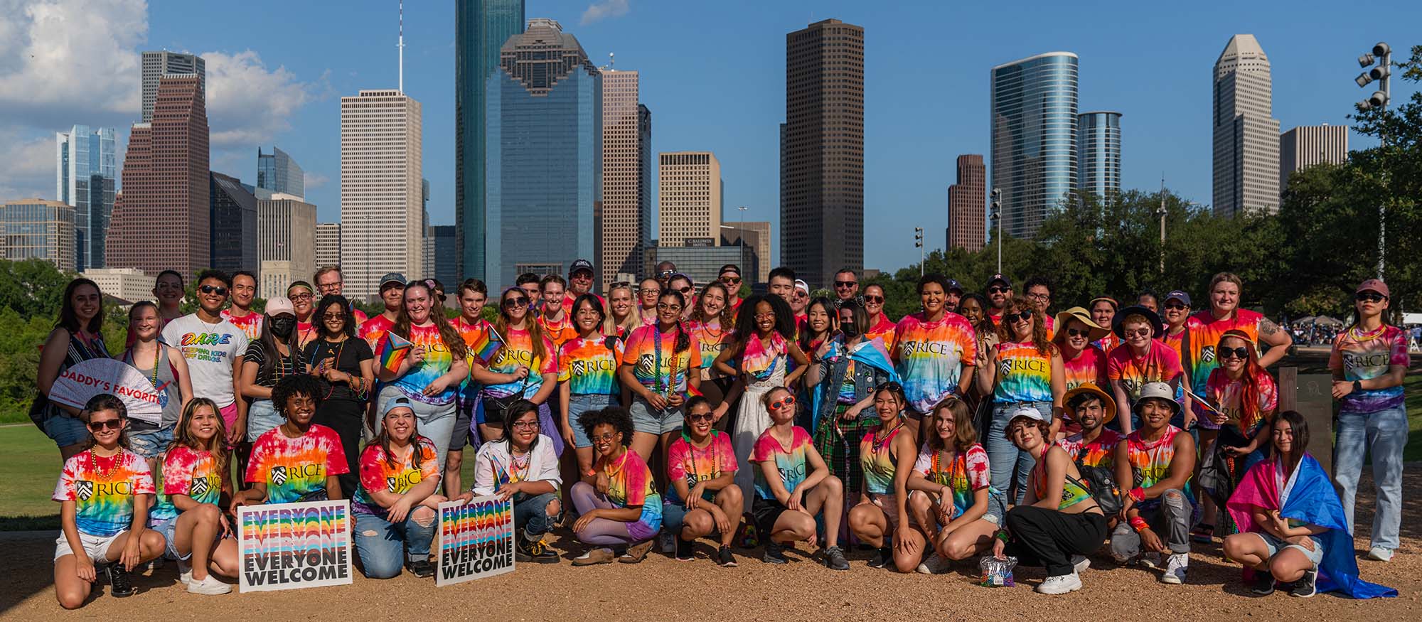 The entire group of parade participants from the Rice community poses for a picture in front of the Houston skyline.