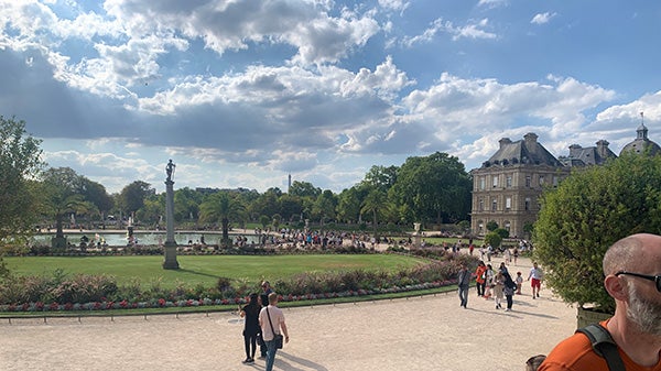 A picture of a large, circular garden area with a large, circular pool of water with a fountain in the middle.