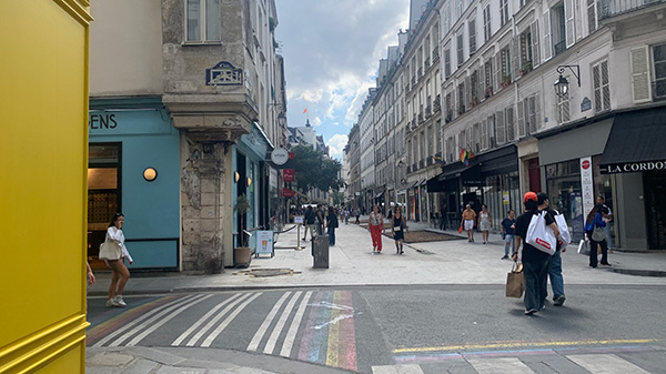 A picture of a street in Paris, with a narrow walkway in front.