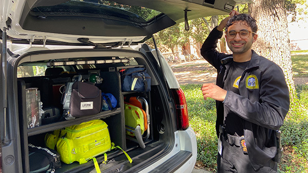 On the right side of the photo, Anthony, a Rice student, stands right next to an open trunk filled with gear for rendering emergency services.
