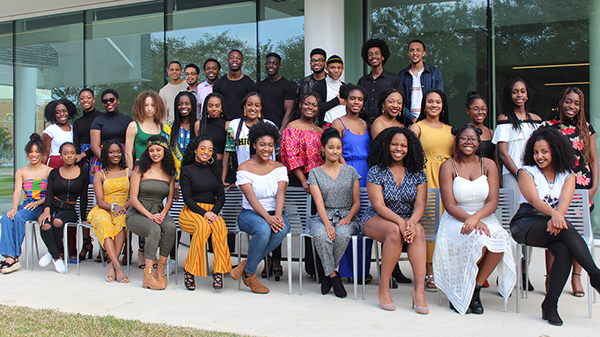 A group of Black Student Association members situated in three rows, with the first row of people sitting down.