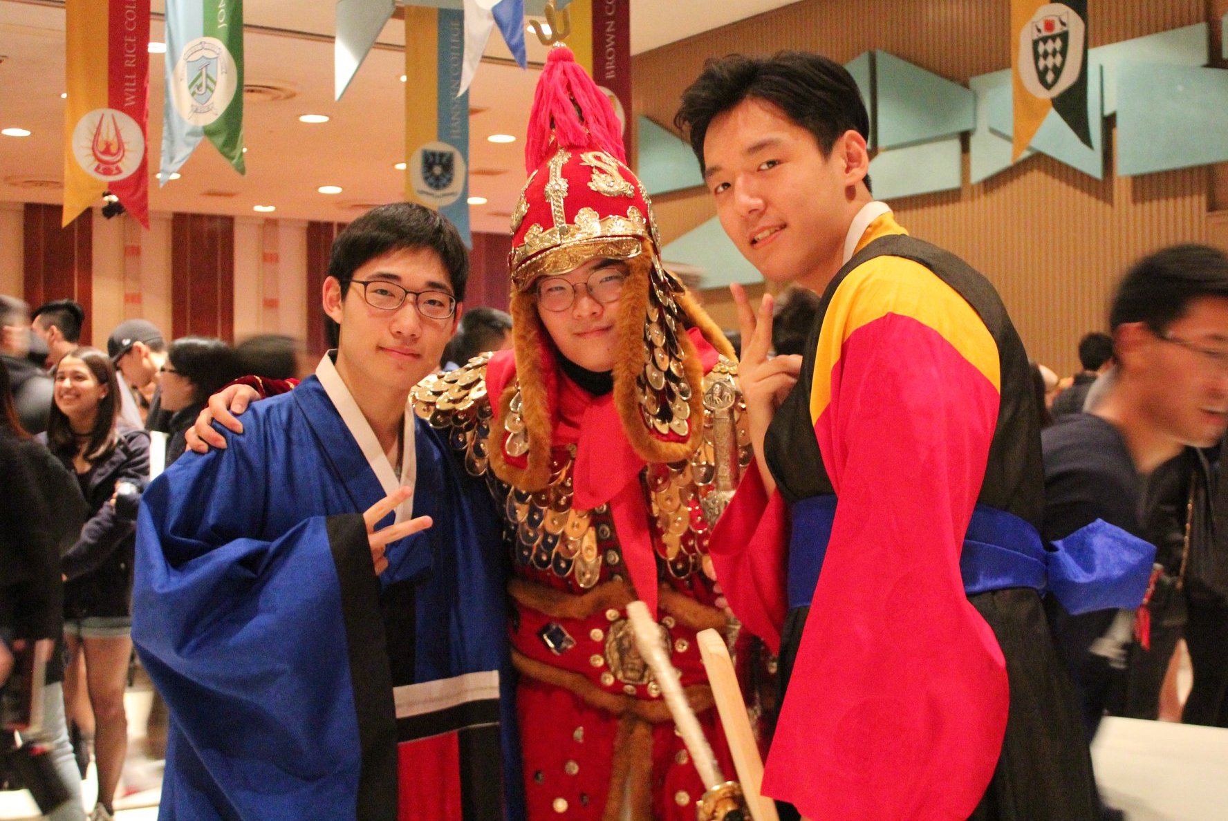 Three students dressed in different types of traditional Korean outfits.
