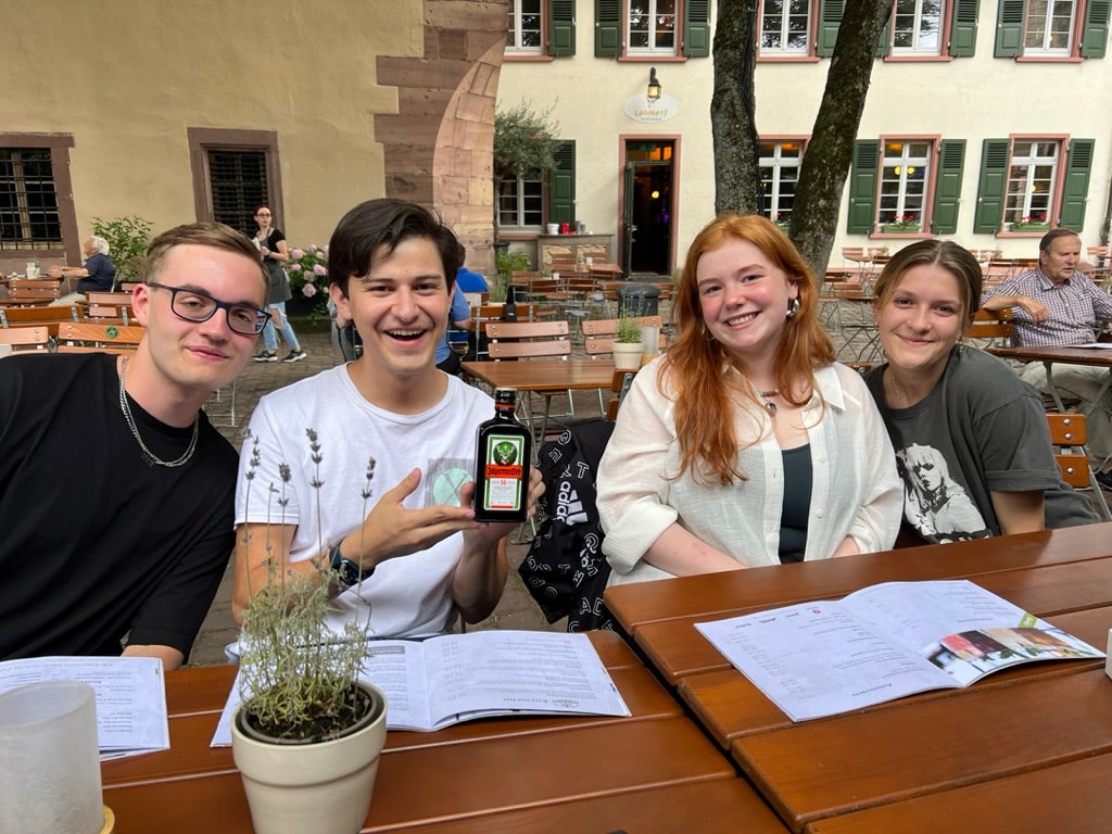 Xavier sitting at a table with two females on his left and a male to his right.