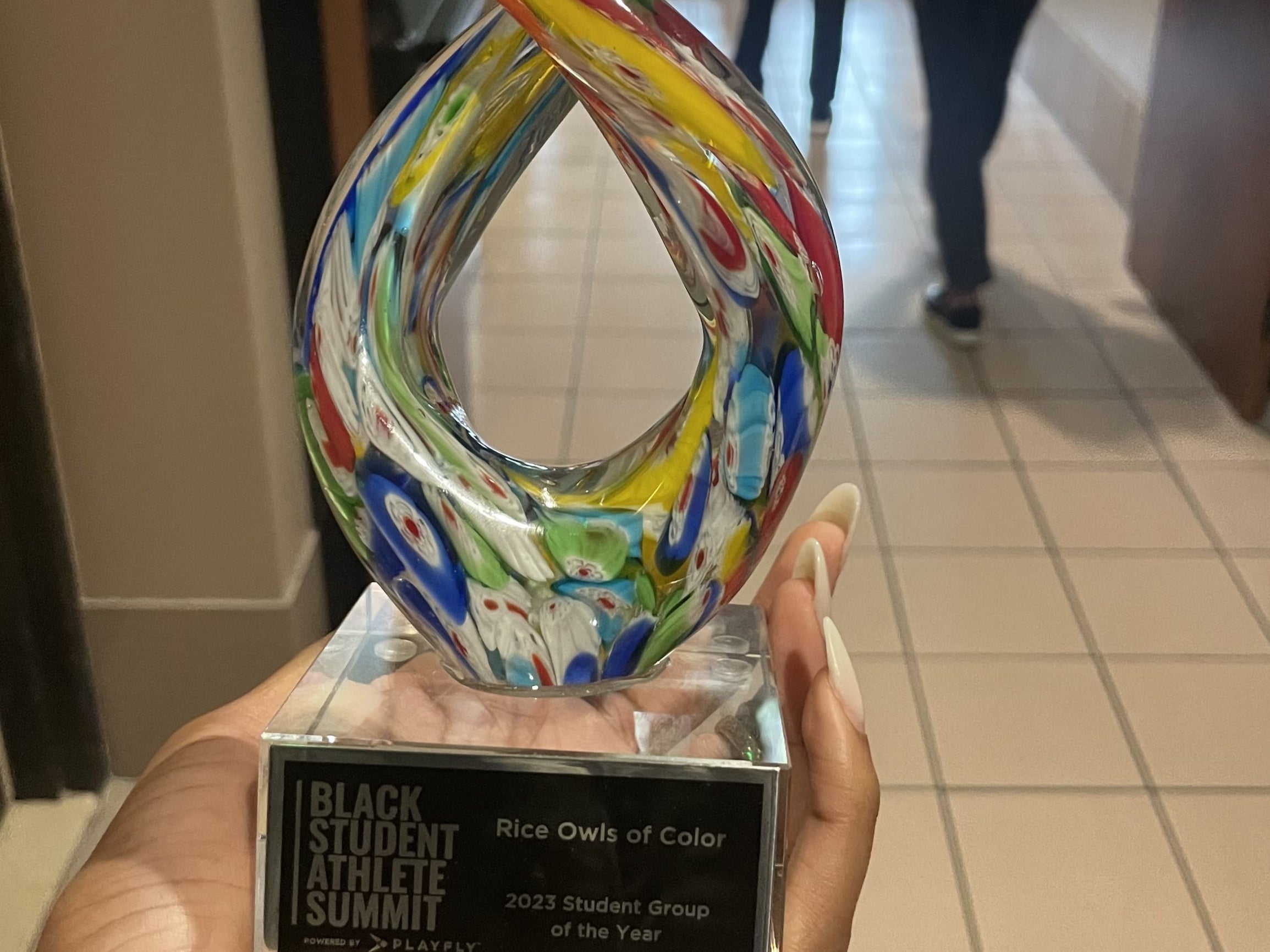 Photo of a hand holding the tropy award 