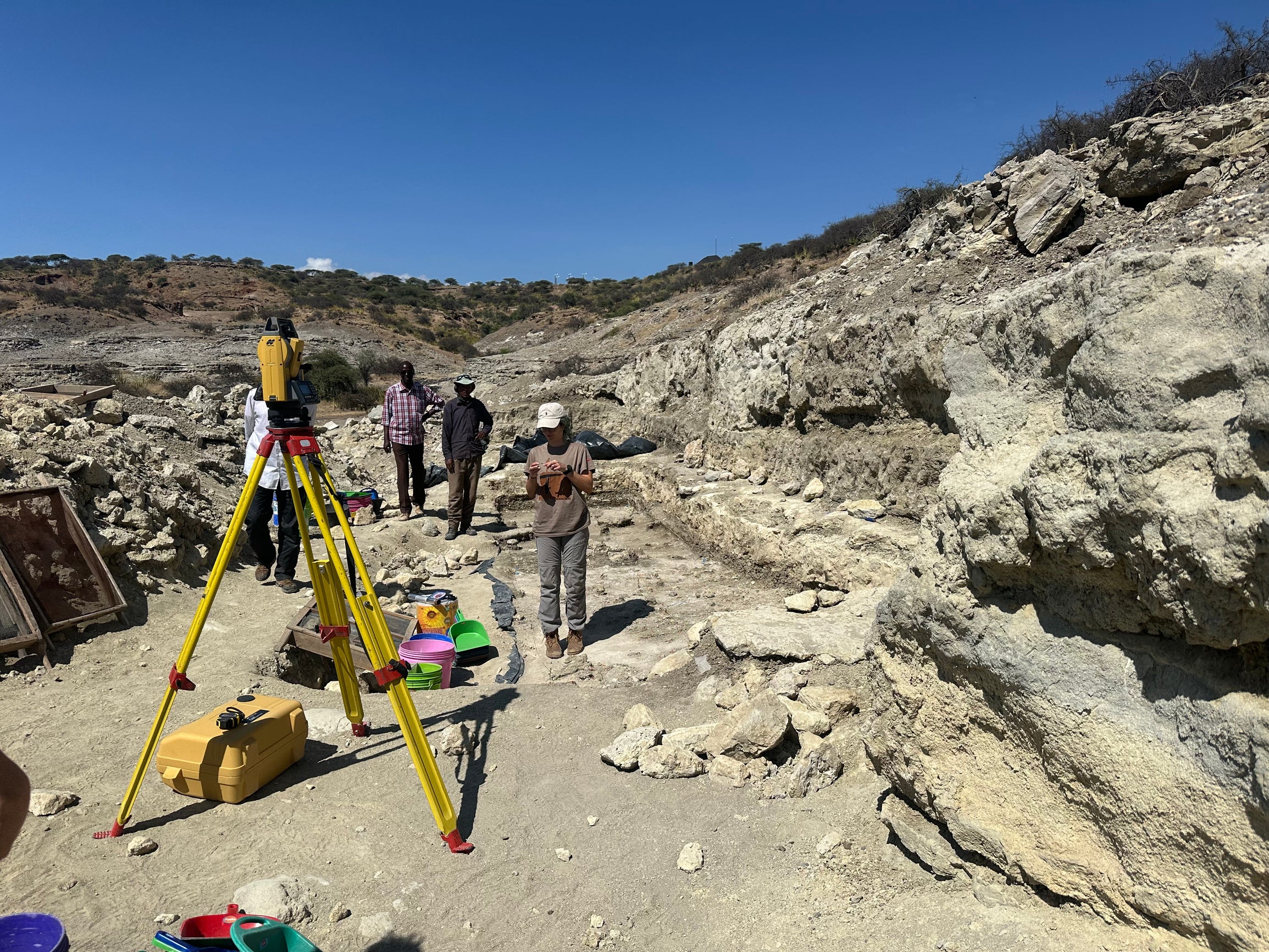 A photo showing students in a rocky mountainous landscape with survey equipment in the foreground