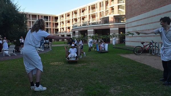 College students playing outside in the grass