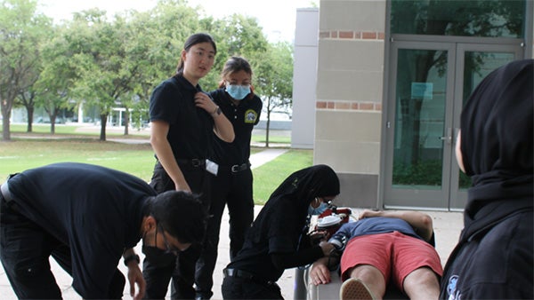 emt students training in using a gurney