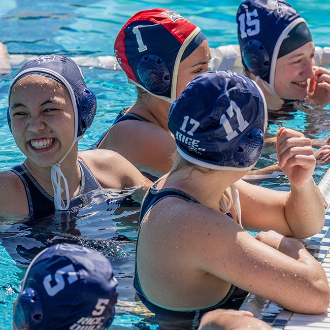 A group of girls talking at the side of a pool