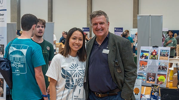 A girl and her professor pose together at an academic fair