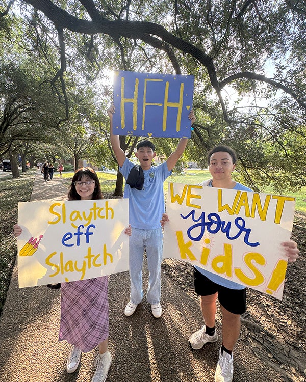 Hanszen residential college students hold up posters to welcome new Hanszenites during O-Week.