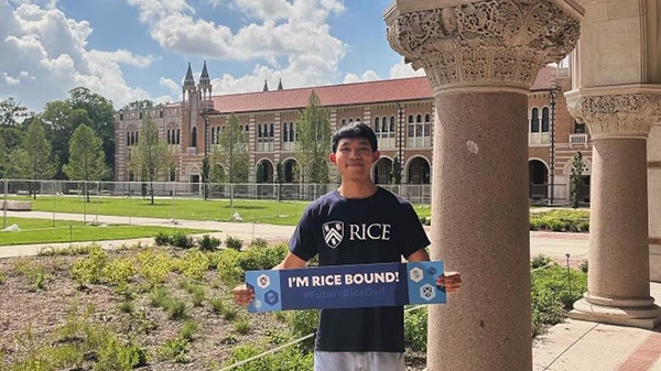 Rice University transfer student Chaianan poses at the Quad with a college acceptance banner