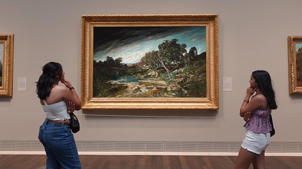 Two girls looking up at art piece