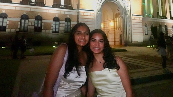 Two girls posing outside lit-up building