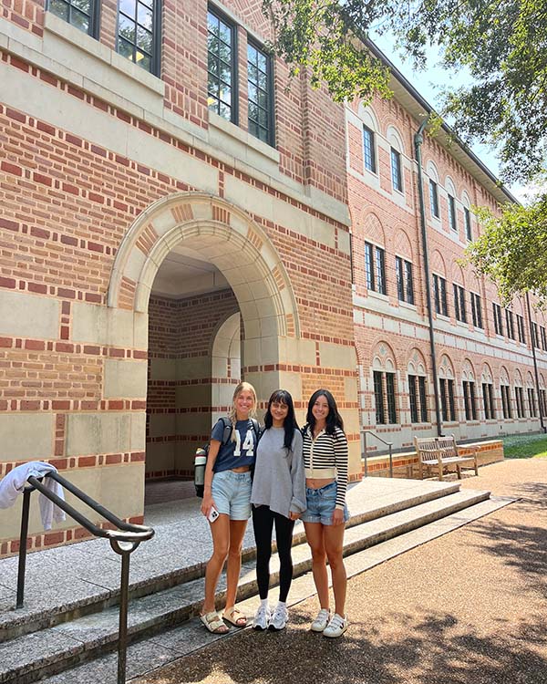 Three girls standing in front of a building