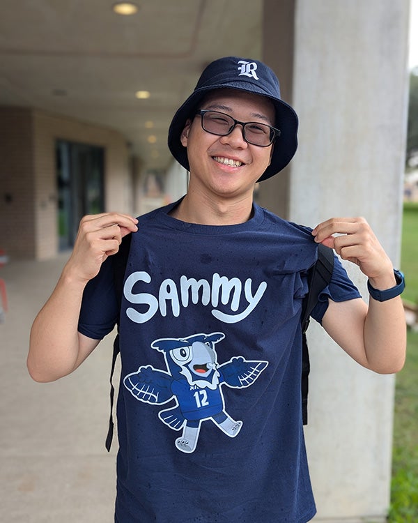 Hong Lin wearing a T-shirt of Rice mascot Sammy