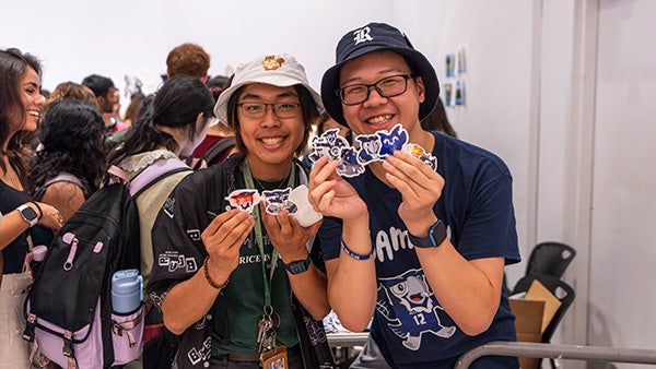 Two boys holding up stickers