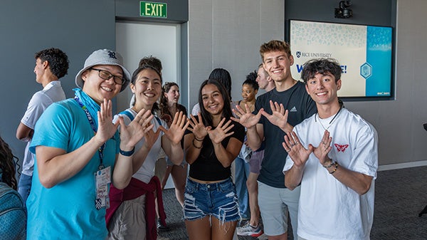 Students holding up Owl hand signs