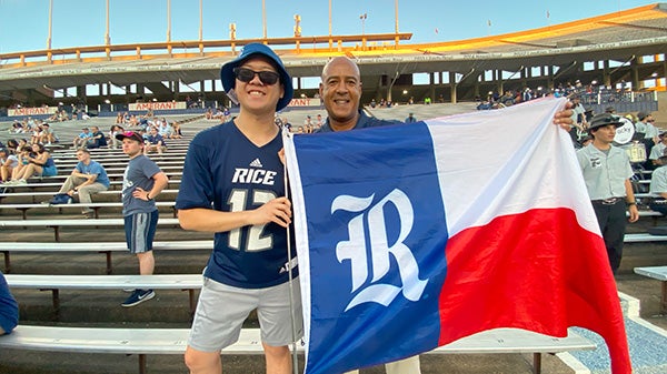 Hong Lin and President DeRoches holding a Rice-themed Texas flag