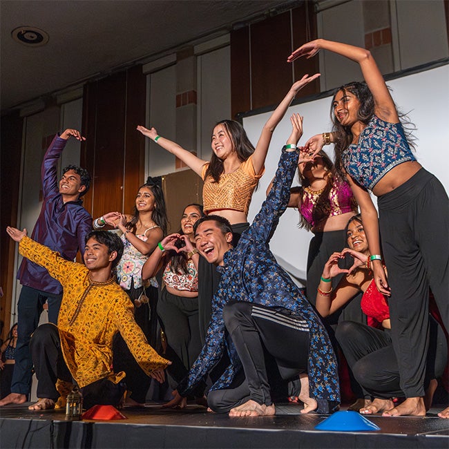 Students pose together with arms out in a final pose