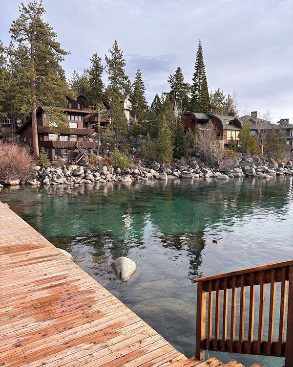 A deck, trees, and cabins beside a large lake