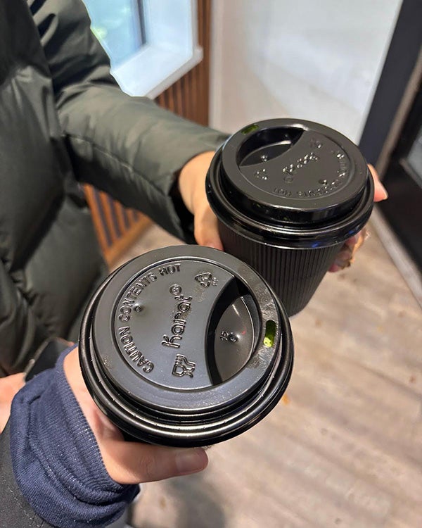 Aerial shot of two coffee cups with disposable lids