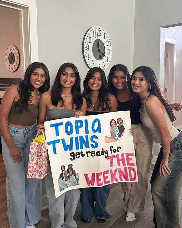 Five girls holding up a poster that says "Topia Twins get ready for The Weeknd"