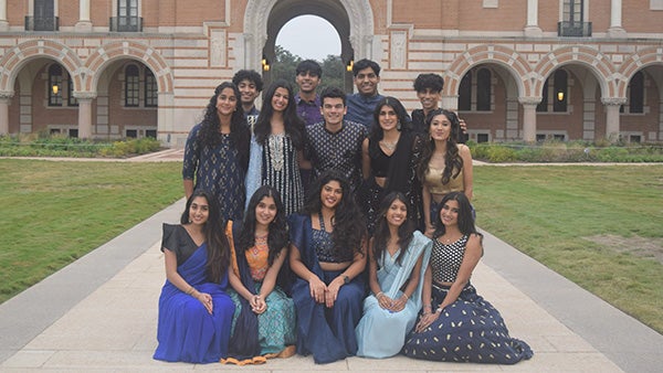 A large group of students wearing Indian clothes outside of a building