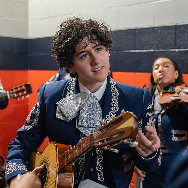 Person in Mariachi wear holding a guitar