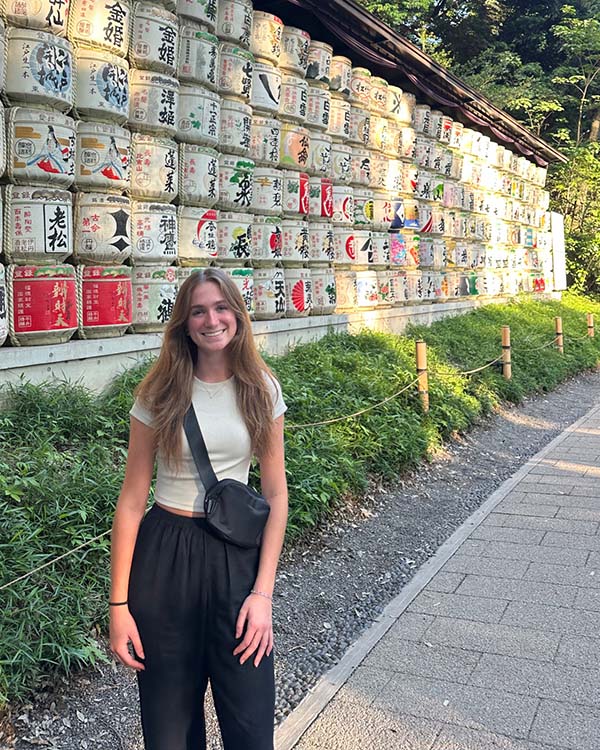 Girl in front of wall of lanterns with Japanese lettering on it