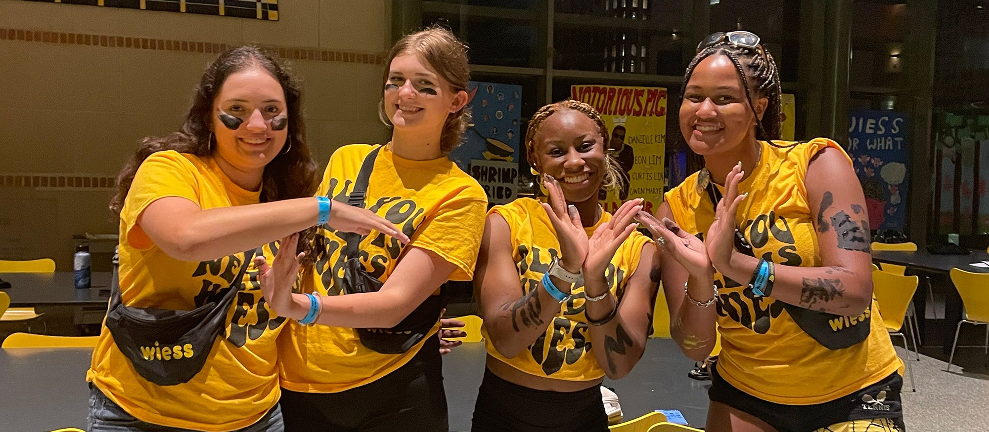 Four girls in matching yellow T-shirts and face paint