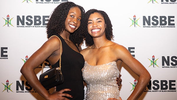 Two girls posing in formal dresses