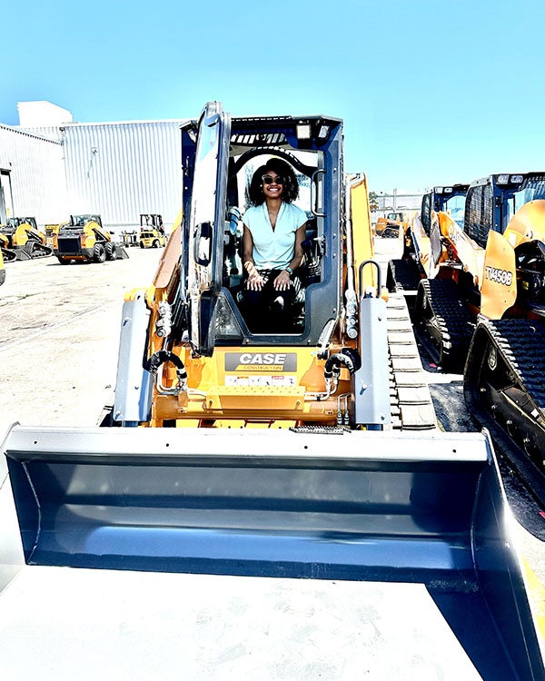 Girl sitting in a large construction vehicle 