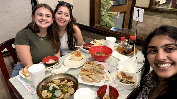 Selfie of three girls, showing the food on the table