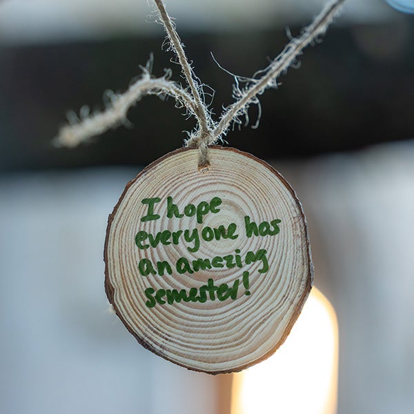 A wood circle with writing on it: "I hope everyone has an amazing semester!"