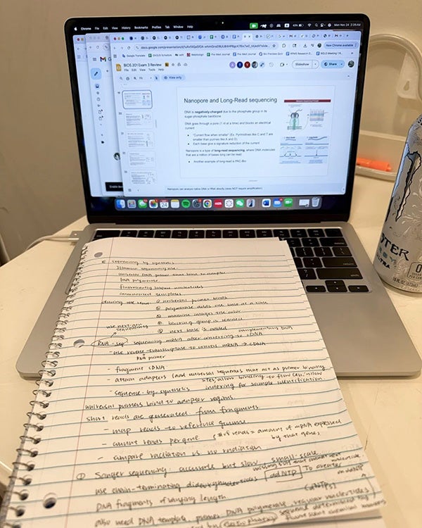 Notebook with notes scrawled across a page and an open laptop