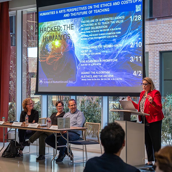 People presenting in front of a screen with a projected slideshow 
