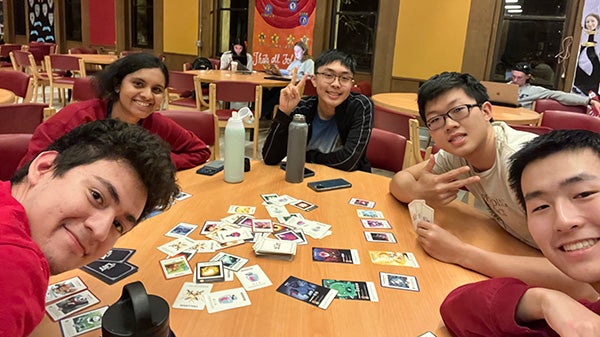 Selfie of people sitting around a table with cards on it
