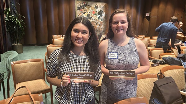 Two girls holding up plaques