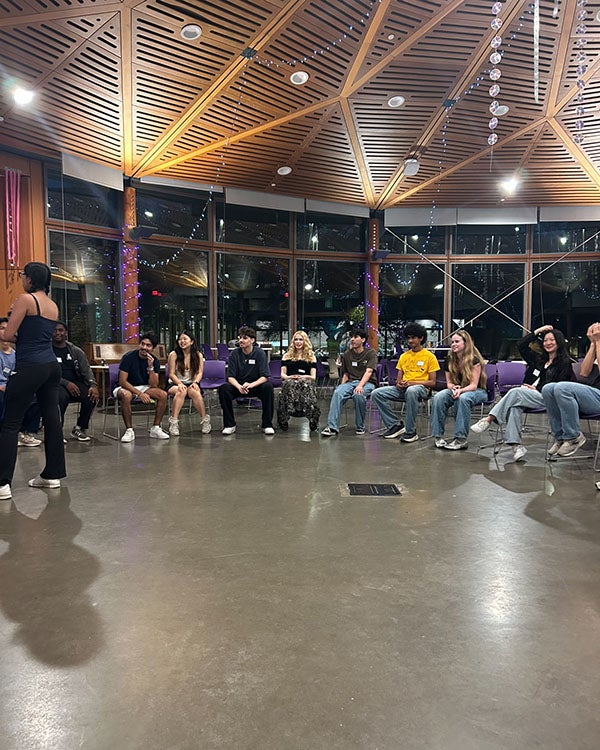 People sitting on chairs in a row in a large, open hall