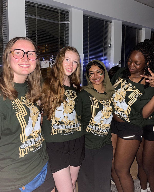 four people in matching shirts indoors at night